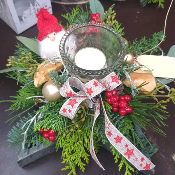 Kleiner Adventskranz in den Farben rot und weiß mit kleinem Weihnachtswichtel.