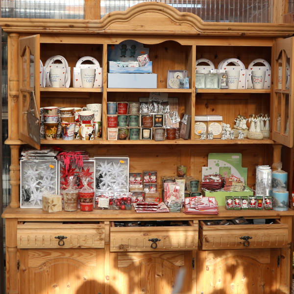 Ein rustikaler Eichenholzschrank mit allerlei kleinen Dekogegenständen für die Advents- und Weihnachtszeit.