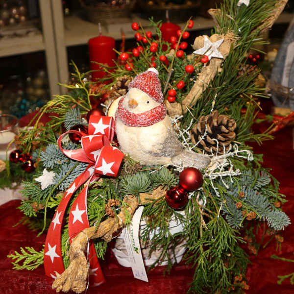 Winterliches Gesteck mit Vogelfigur.