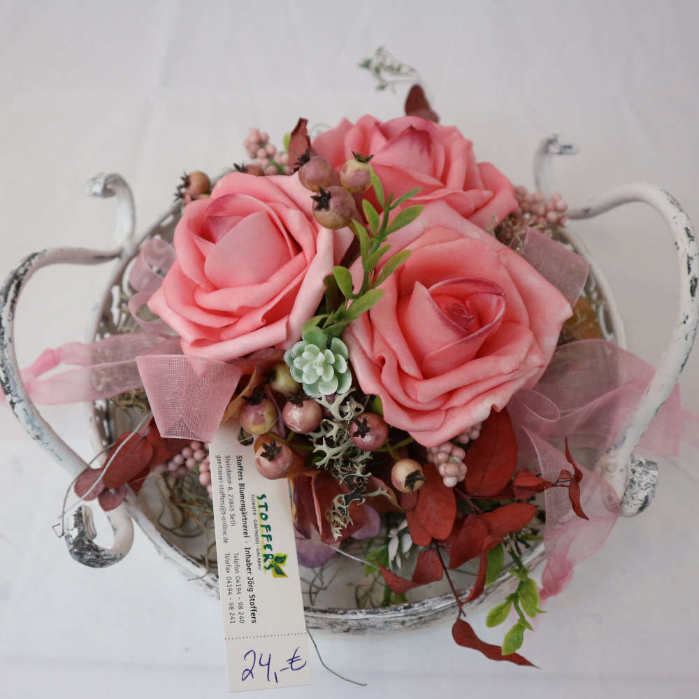 Ein Dekotablett im Vintage-Stil, welches mit Kunstblumen und Kunstbeeren in rosa dekoriert wurde.