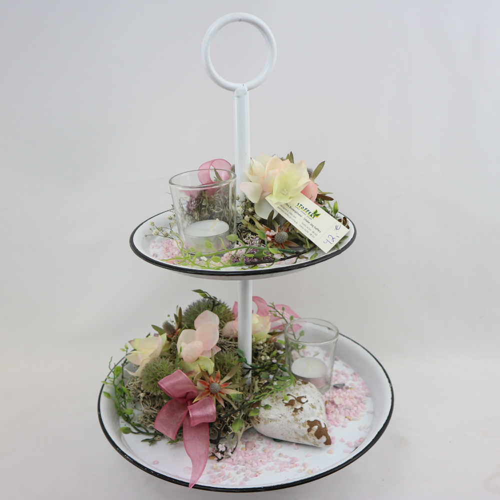  Eine zweigeschossige Etagere, besteckt mit Kunstblumen und Frischblumen zum Eintrocknen in zarten rosa Tönen + großes Steinherz. 