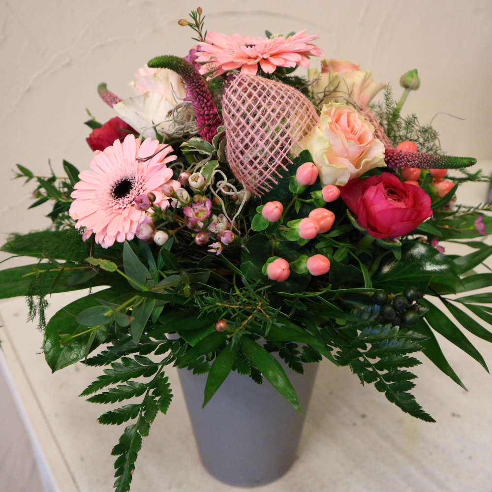 Ein großer, kompakt gebundener Blumenstrauß, bestehend aus rosa Gerbera, aufstrebenden Veroknika und rosa Rosenblüten.