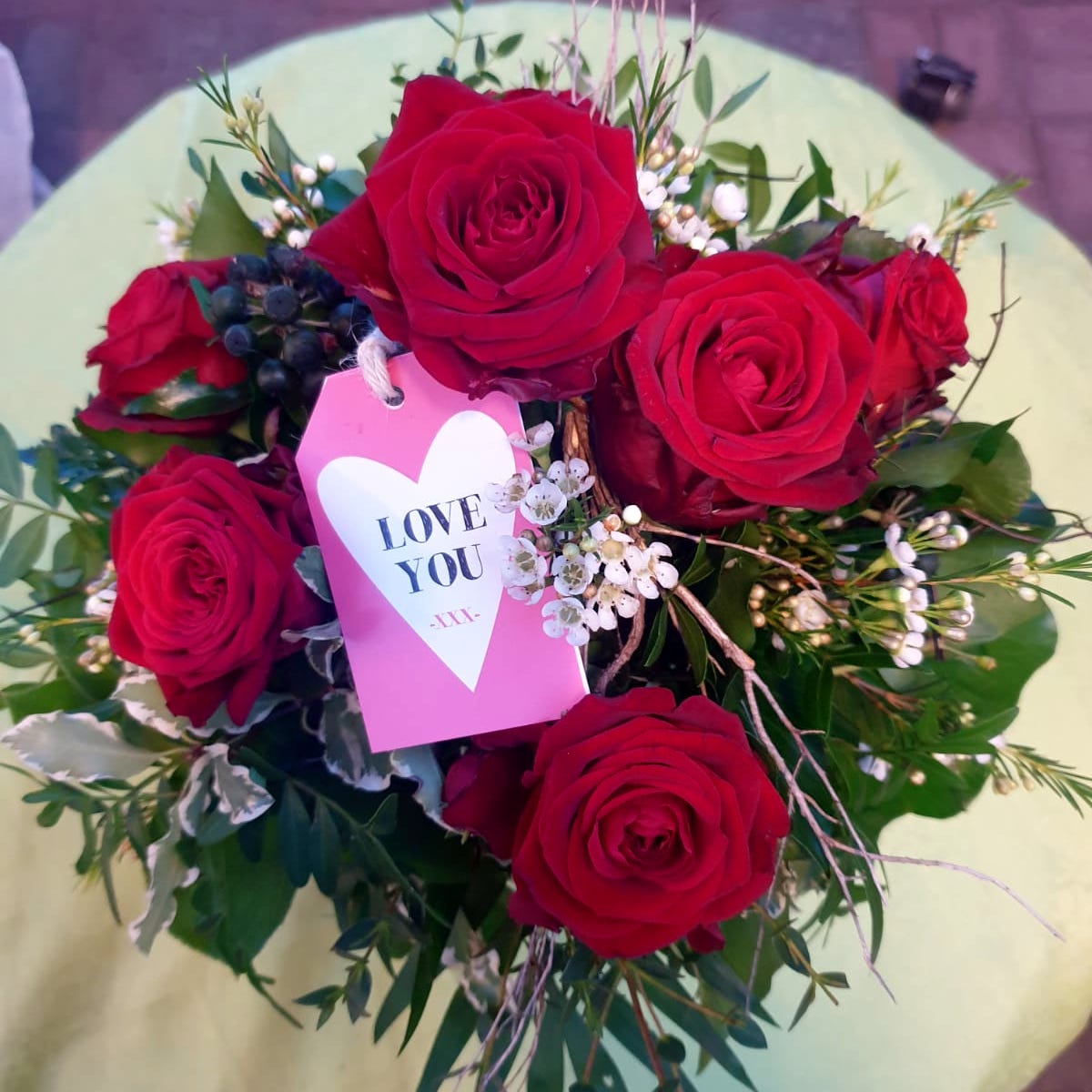 Ein klassischer und zeitloser, rund gebundener Rosenstrauß mit hochwertigem Bindegrün.
