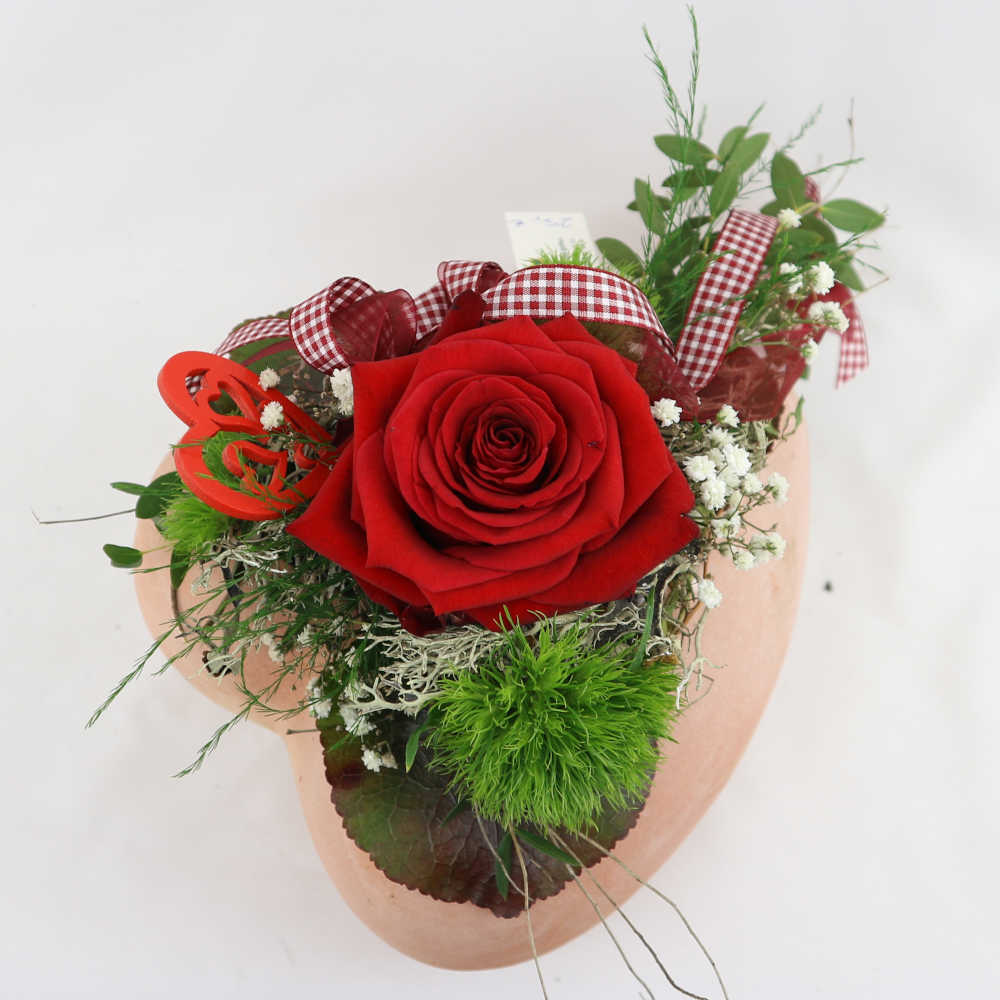  Ein Herz aus Ton, besteckt mit einer roten Rose, Schleierkraut und Nelken. Kann eingetrocknet werden. 